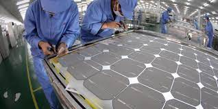 صورة توضح كيف يقوم  العمال ب آلية تصنيع الالواح الشمسية 
